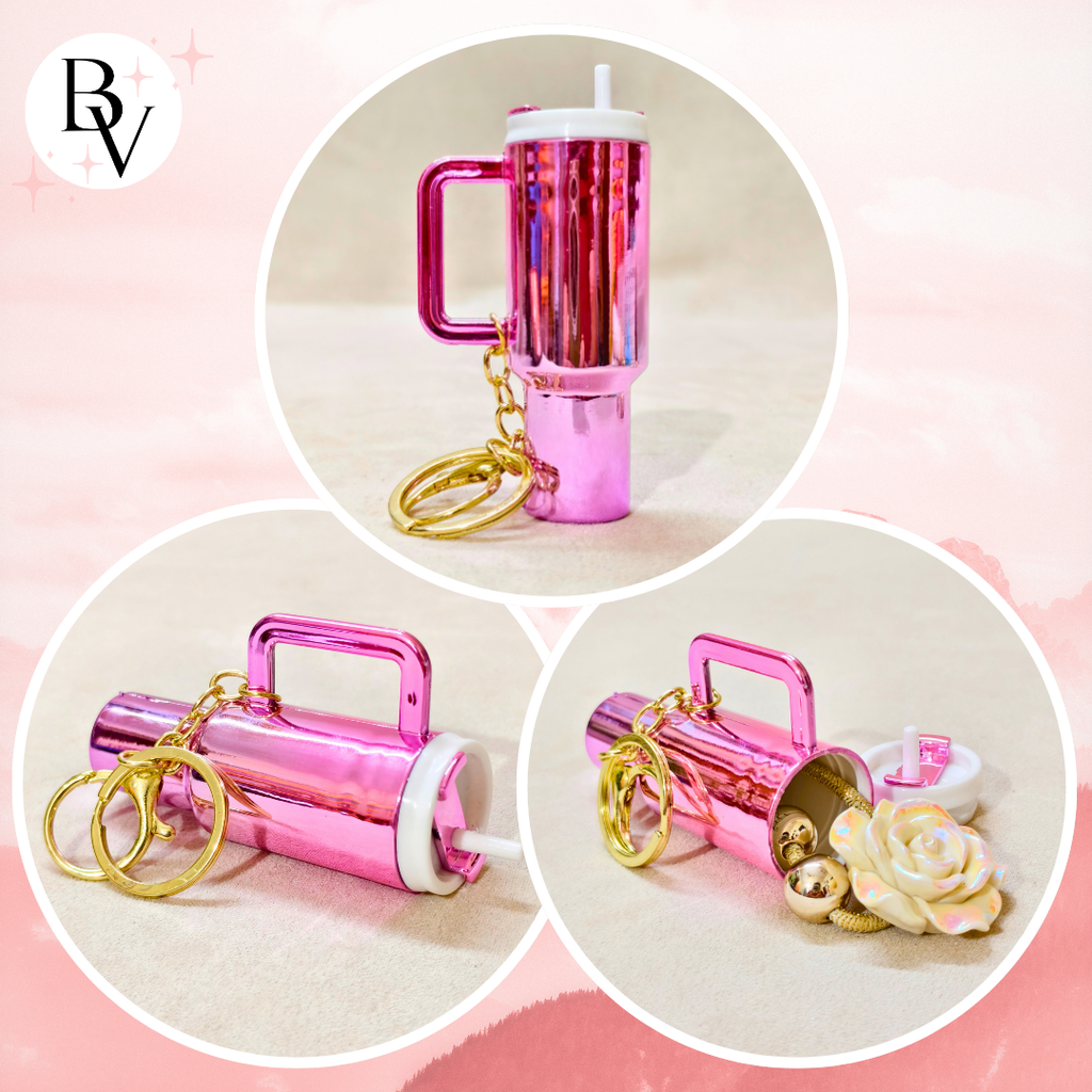 A pink metallic travel tumbler keychain shown in three circular product views on a soft pink background. The tumbler has a handle, a straw, gold key rings, and a small white cap.