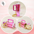 A pink metallic travel tumbler keychain shown in three circular product views on a soft pink background. The tumbler has a handle, a straw, gold key rings, and a small white cap.