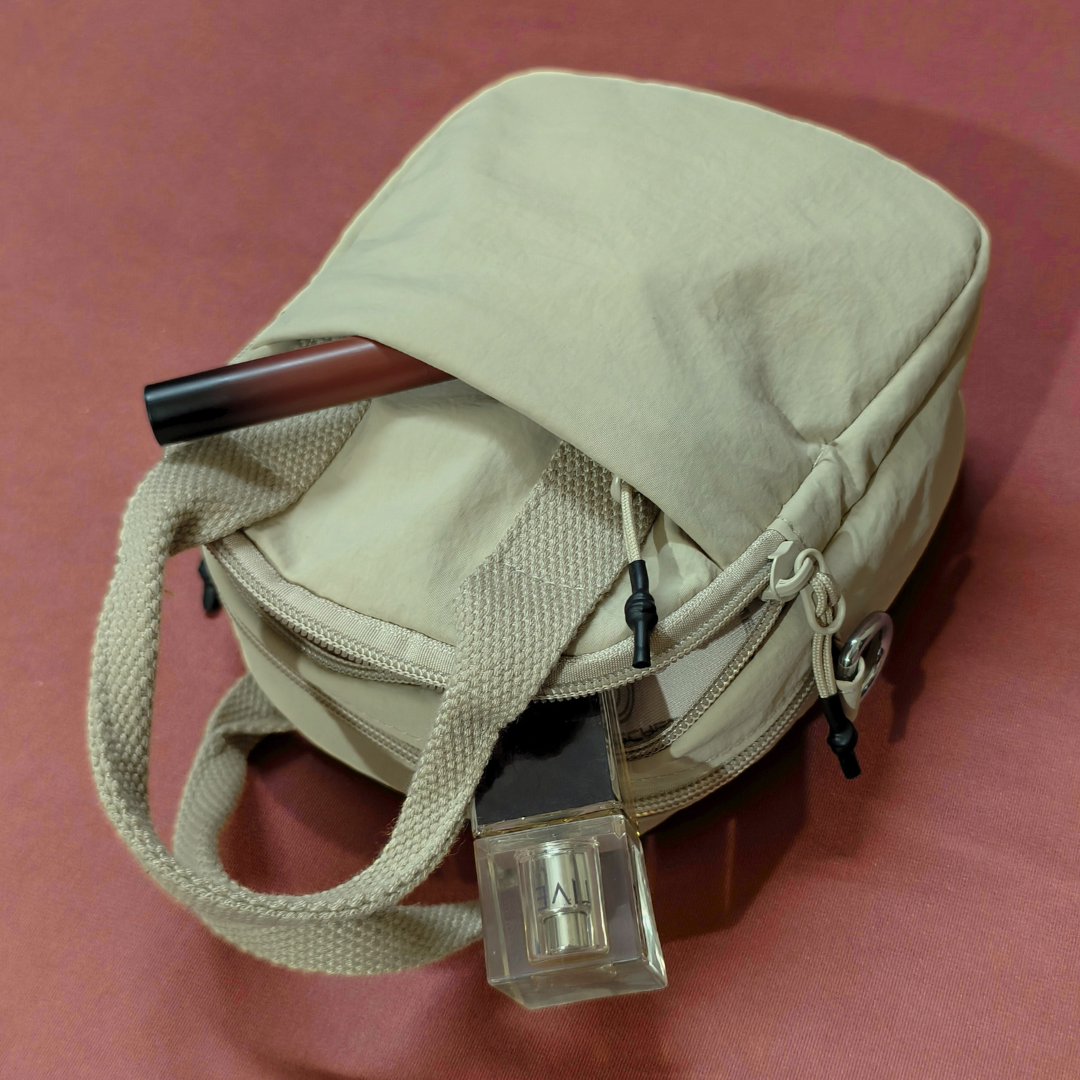 Beige bag with a pen and small device on a red background