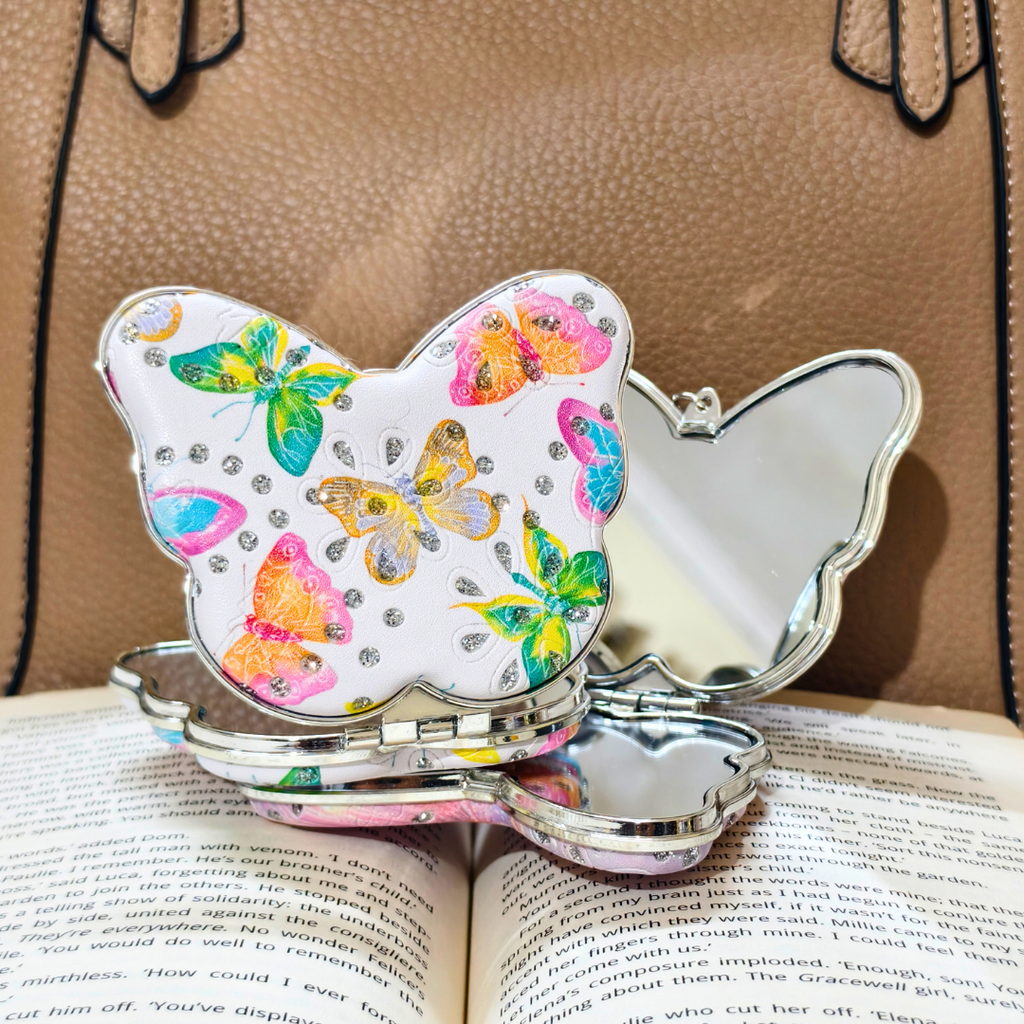 A butterfly-shaped keychain  and colorful butterfly prints, shown with Props.