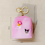 Pink keychain with cartoon characters and measurements on a beige background