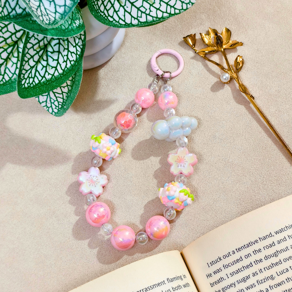 Colorful beaded bracelet with floral designs on a beige surface with a book and decorative elements.