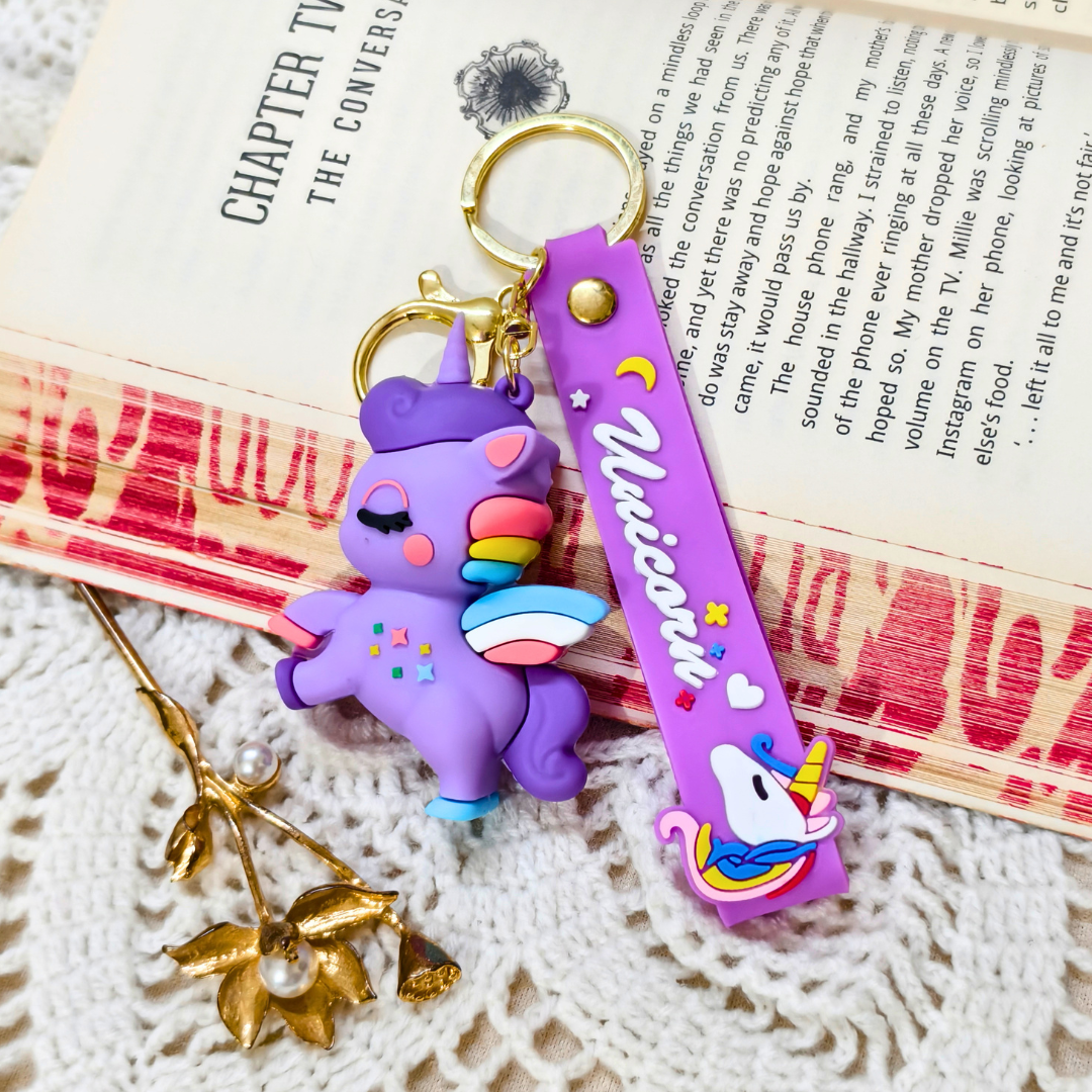 Purple unicorn keychain with rainbow accents on a textured surface