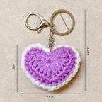 Crocheted heart keychain with measurements on a beige background