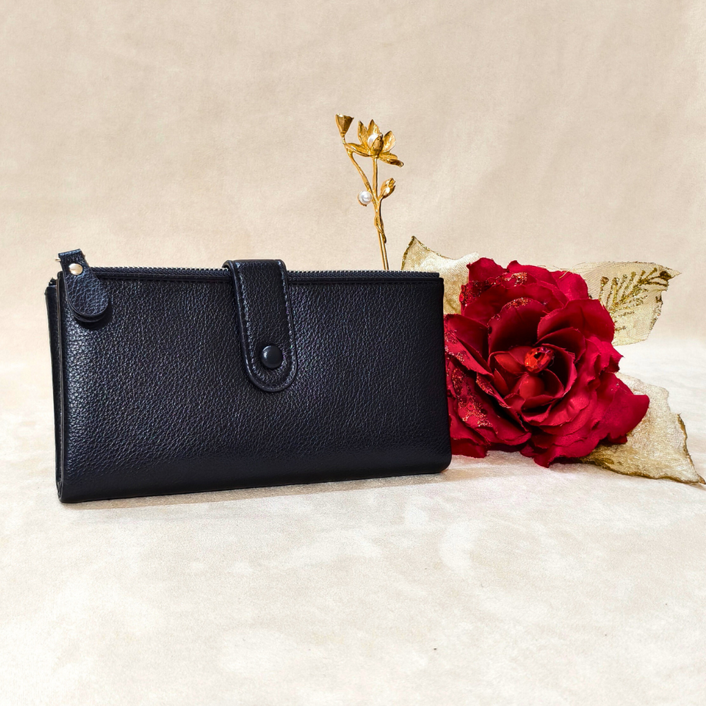 Black wallet on a white surface with a red rose and gold leaf
