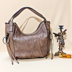 Brown leather handbag with a decorative figurine on a beige background
