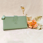 Mint green wallet with decorative flowers on a beige background