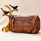 Brown leather bag with a decorative bird stand on a beige background