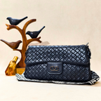 Quilted navy handbag with brand logo on a beige background