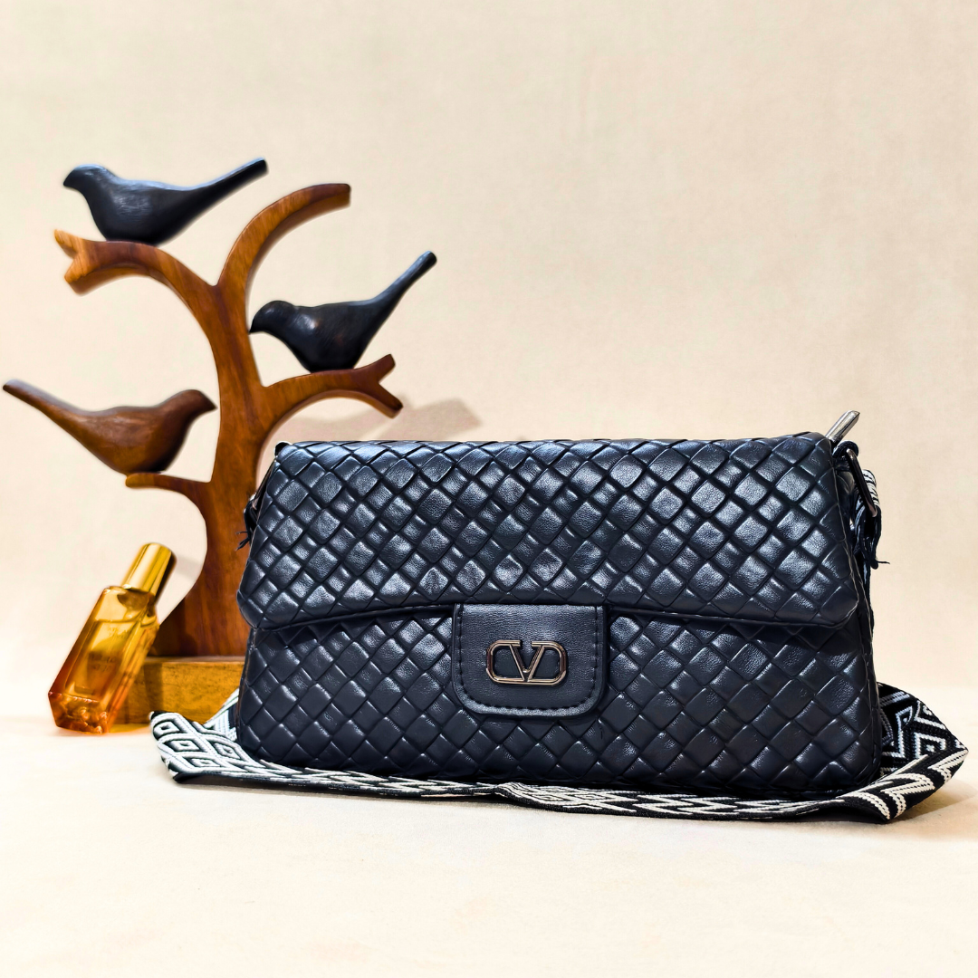 Quilted navy handbag with brand logo on a beige background
