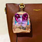 Decorative phone case with sequins and a butterfly on a brown leather bag.