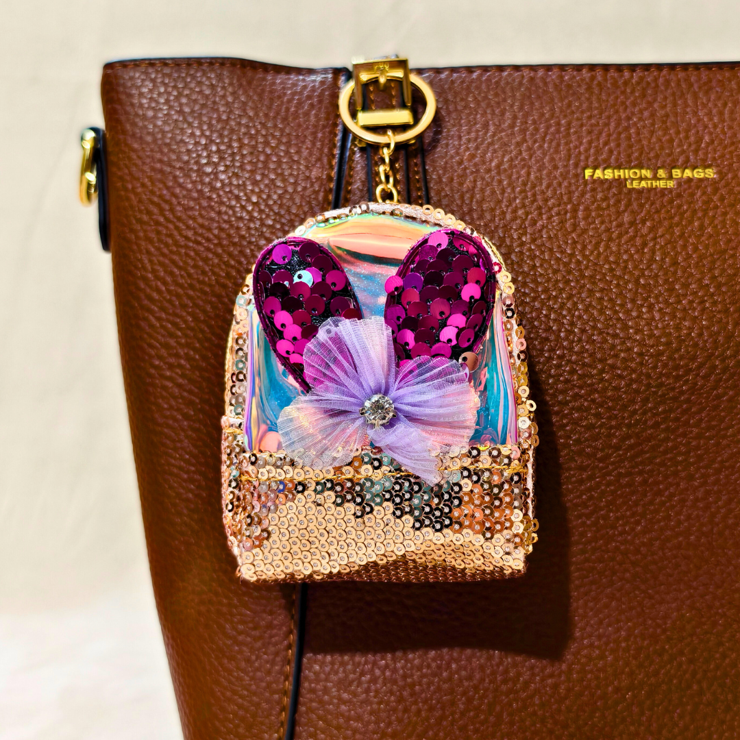 Decorative phone case with sequins and a butterfly on a brown leather bag.