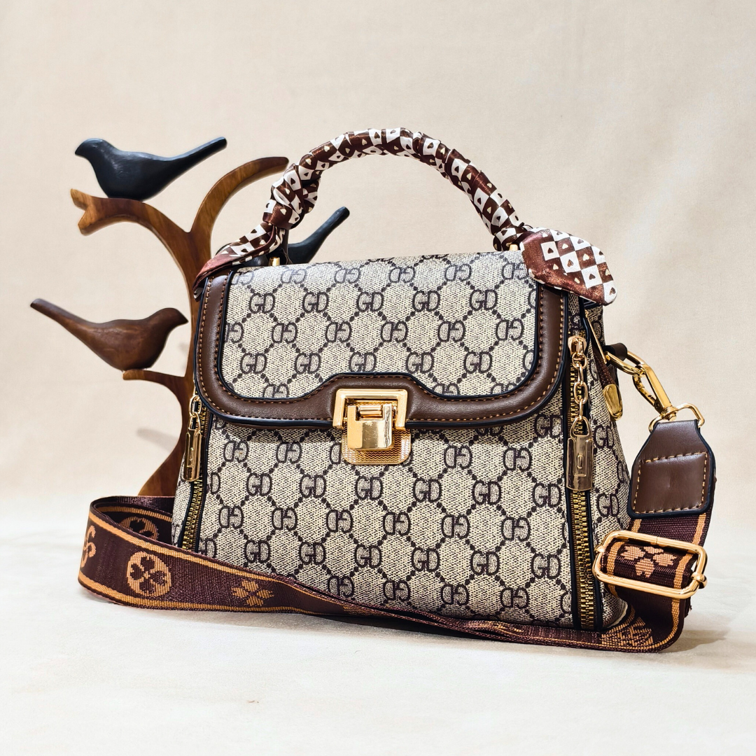 Designer handbag with patterned design and gold accents on a neutral background