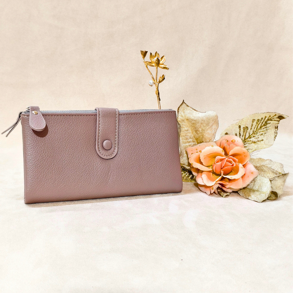 Pink wallet on a beige surface with decorative flowers