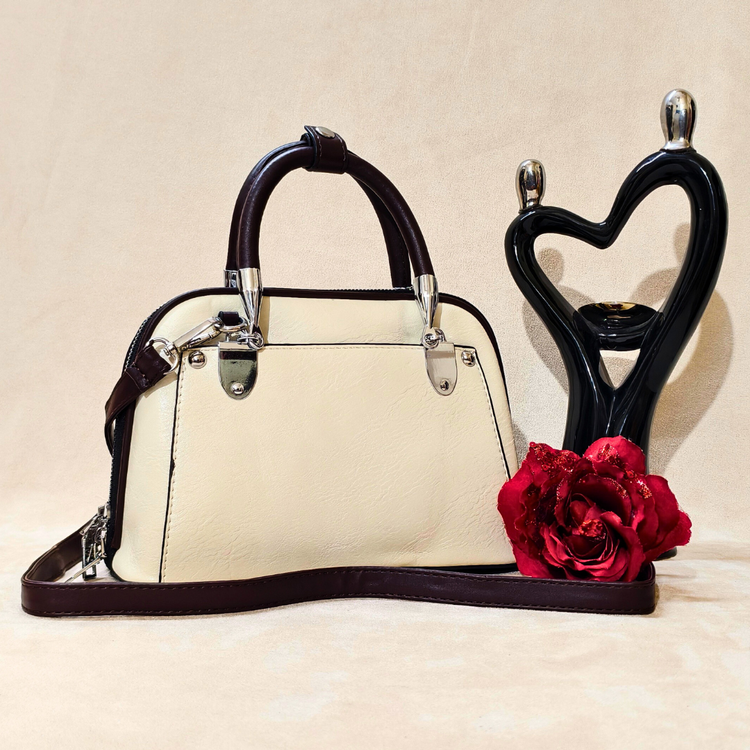 Beige handbag with black handles and trim, next to a decorative heart-shaped stand with a red rose on a beige background.