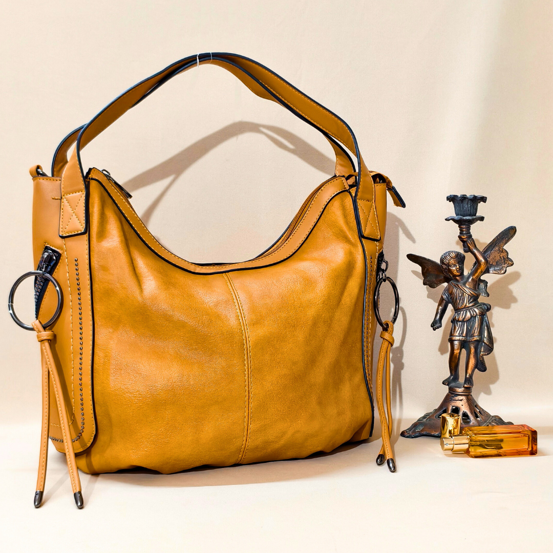Brown leather handbag on a white surface with decorative items.