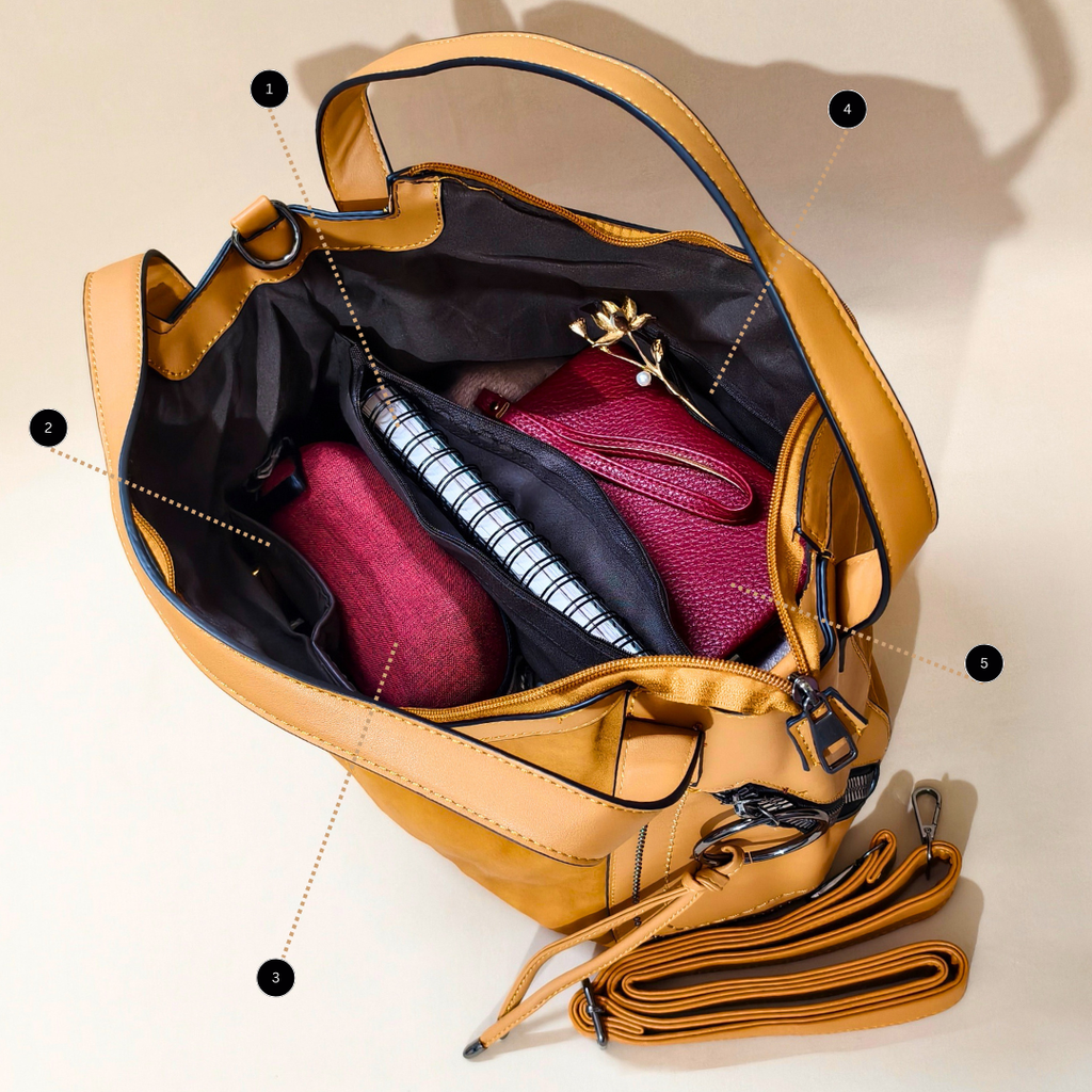 Open tan leather bag with a pink pouch and notebook on a beige background
