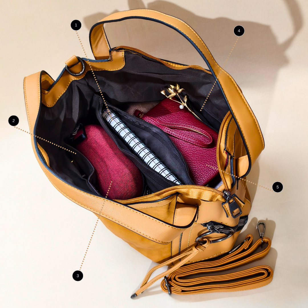 Open tan leather bag with a pink pouch and notebook on a beige background