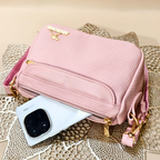 Pink handbag with gold accents on a textured surface