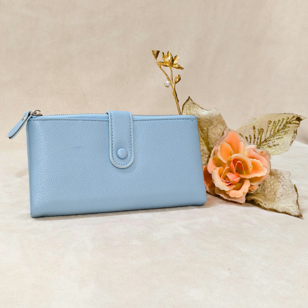 Light blue wallet on a beige surface with a decorative flower arrangement.