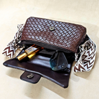 Brown woven handbag with a strap on a beige background