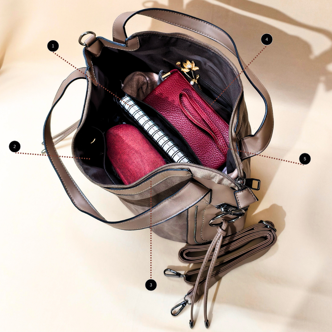 Open beige handbag with pink pouch and notebook on a beige background