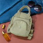 Beige handbag with sunglasses and a bottle on a pink surface