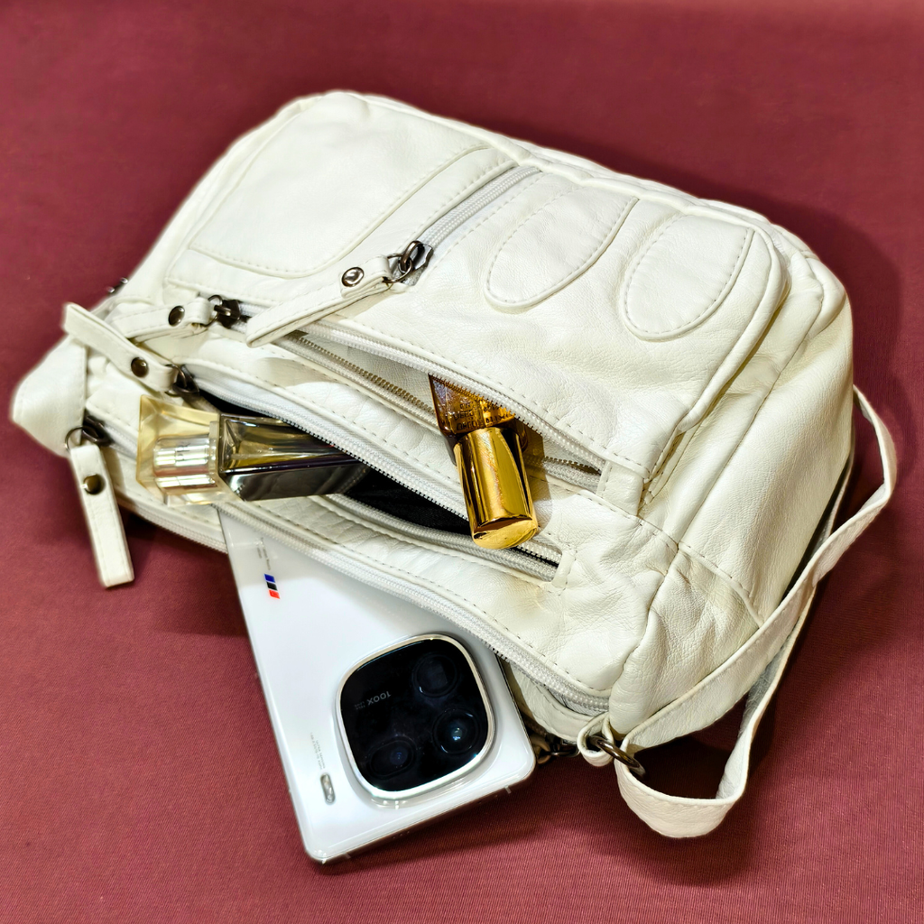 White quilted handbag with gold accents on a red background