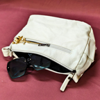 White pouch with sunglasses on a red background