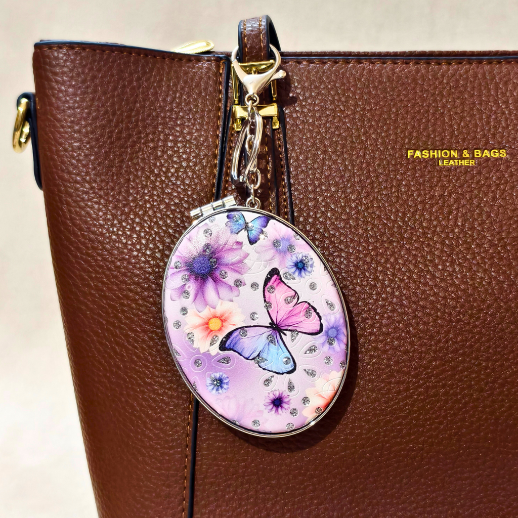 Oval Butterfly Pocket Mirror Attached With Purse As  Bag Charm On  Beige Background.