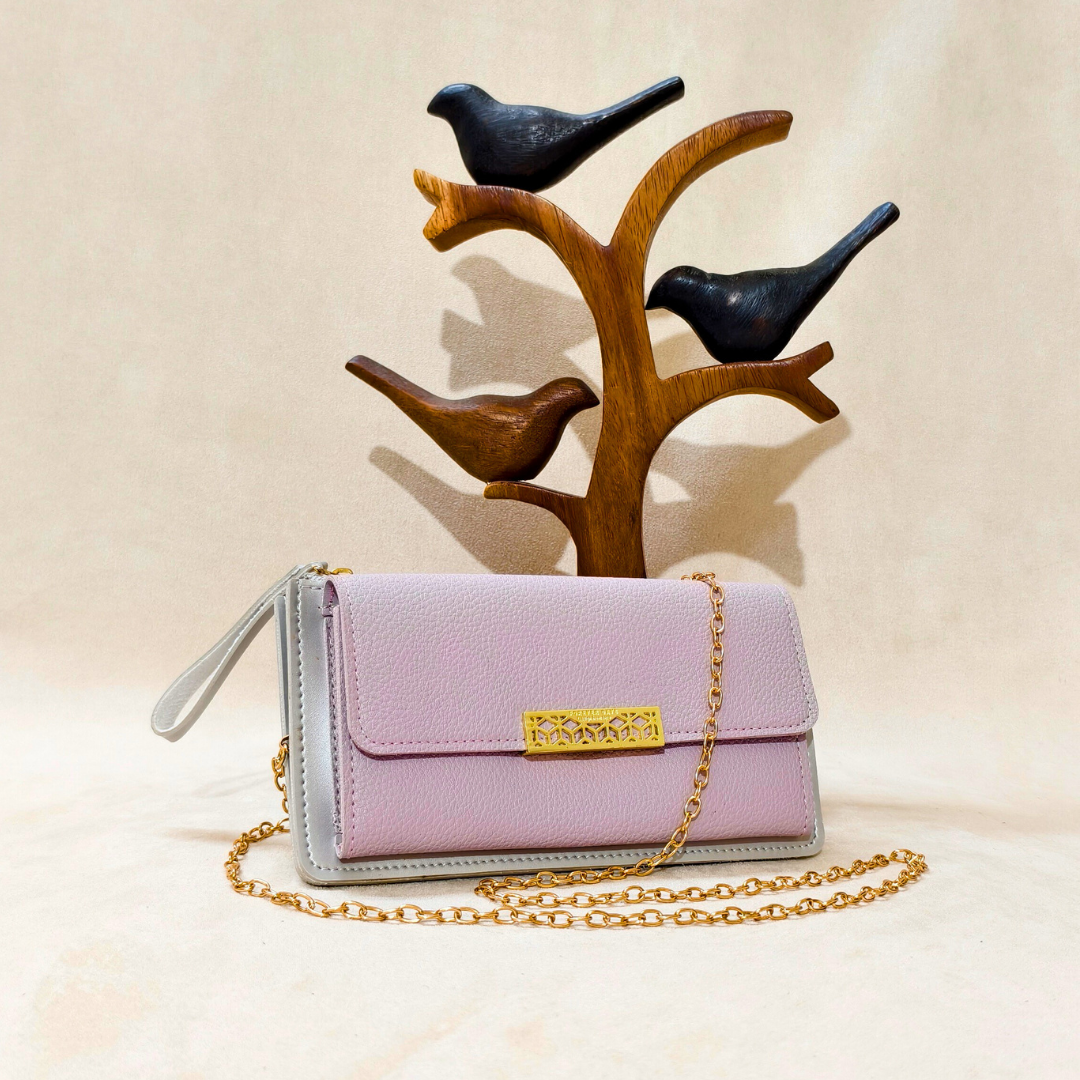 Pink handbag with gold chain and clasp in front of a wooden bird stand on a beige background