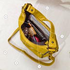 Yellow handbag with various items inside on a light background