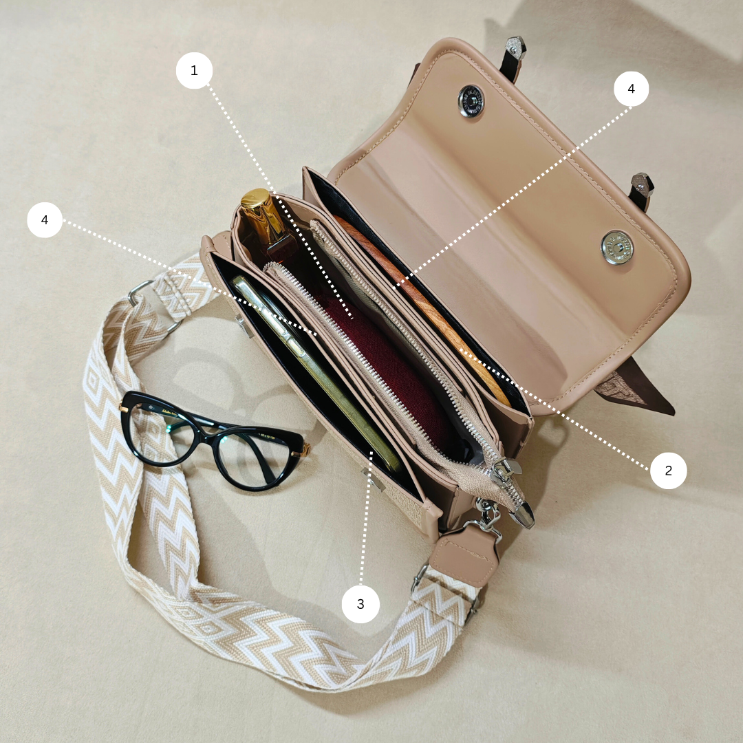 Beige handbag with a strap, glasses, and a bottle on a beige background