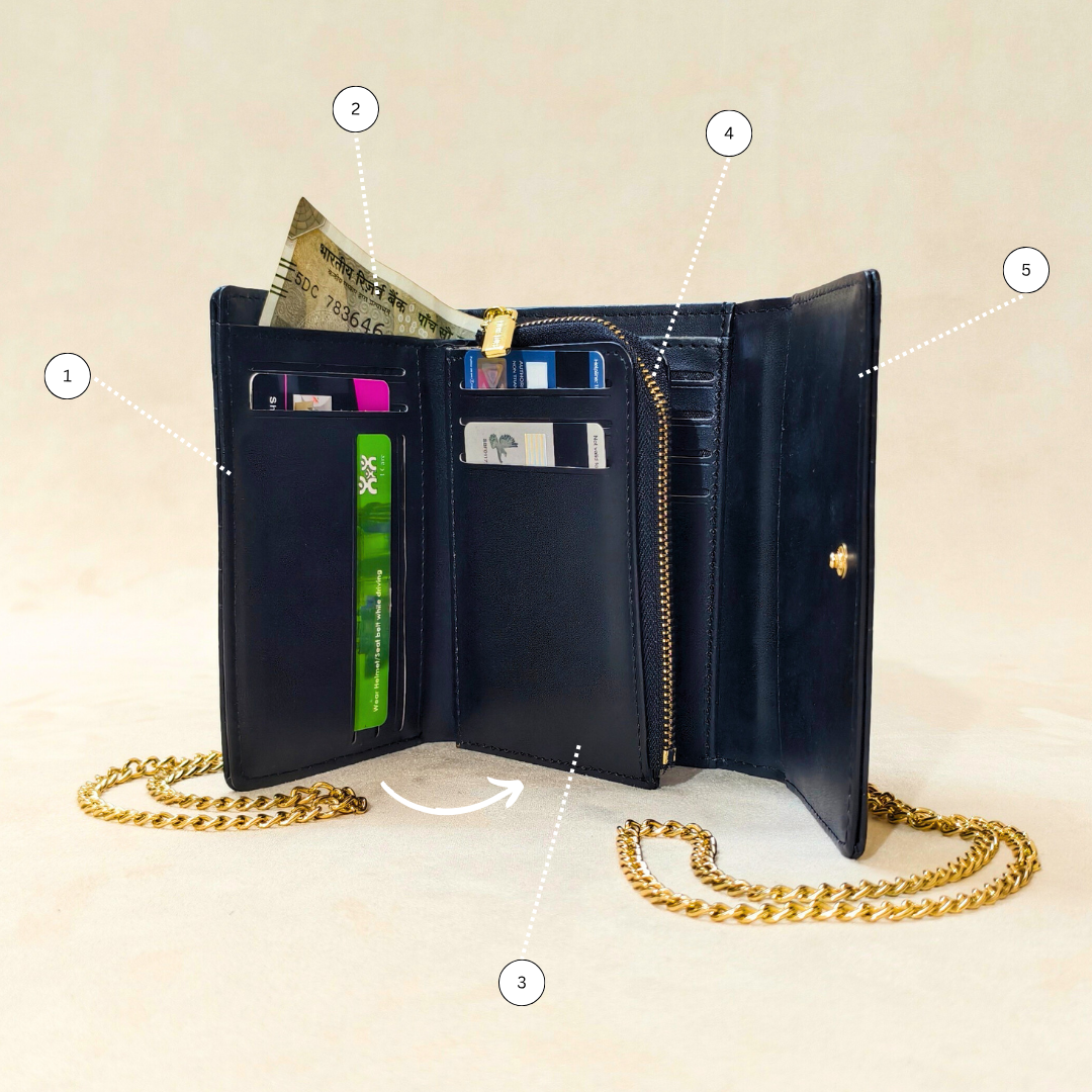 Black wallet with gold chain on a beige background