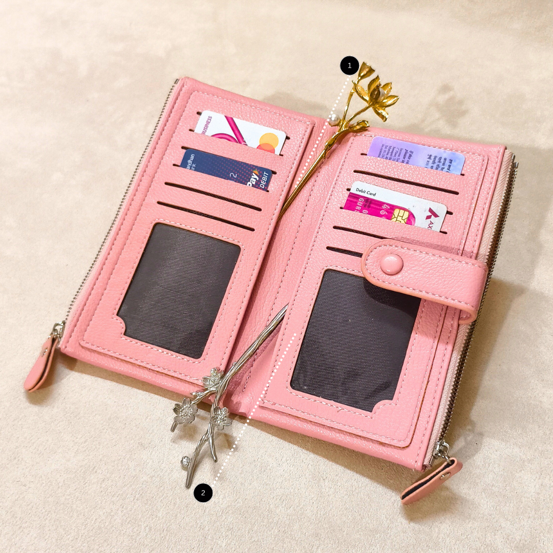 Pink wallet with card slots and a decorative flower on a beige background