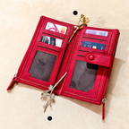 Red wallet with card slots and a zipper on a beige background