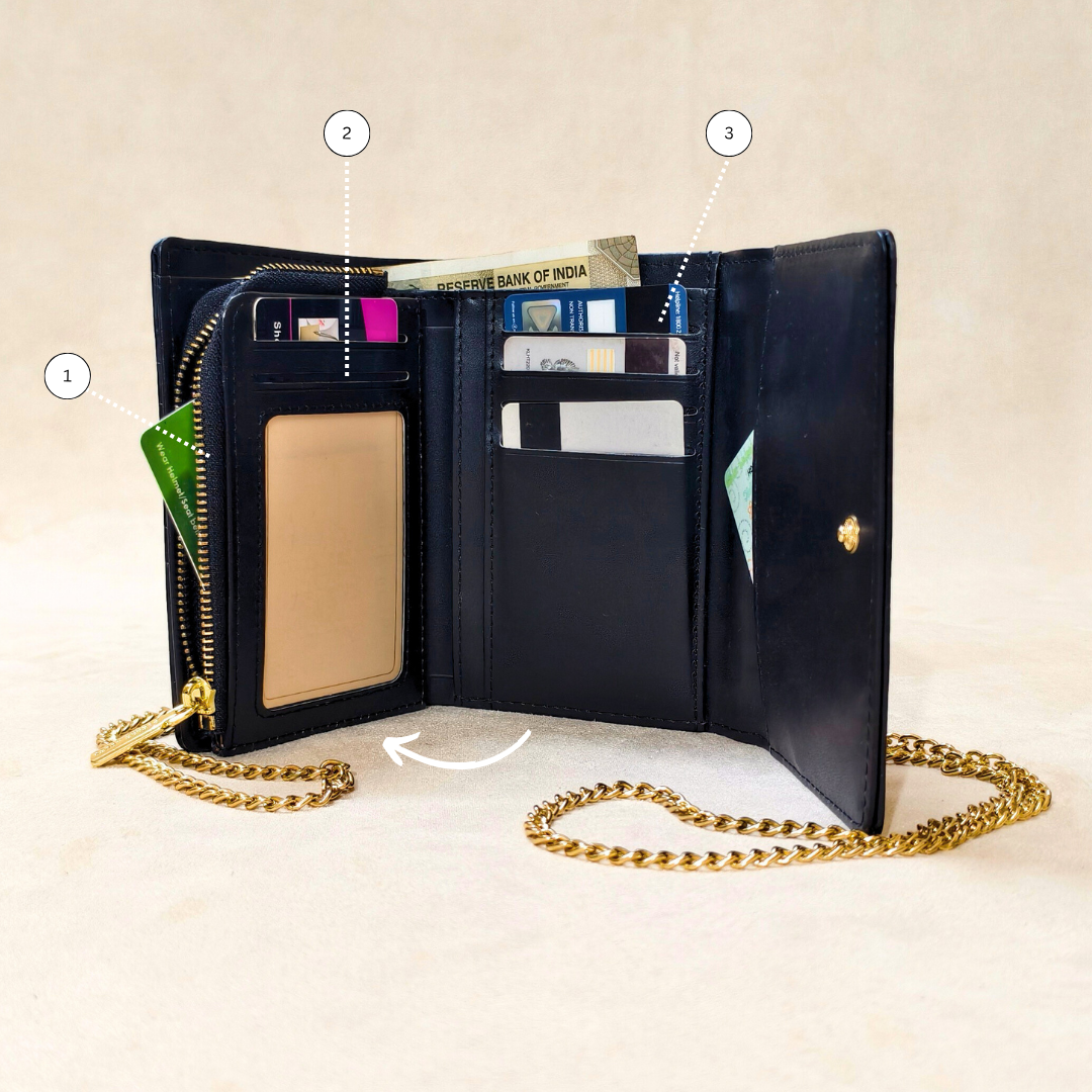 Black wallet with gold chain on a beige background