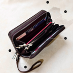 Open black wallet with compartments on a beige background