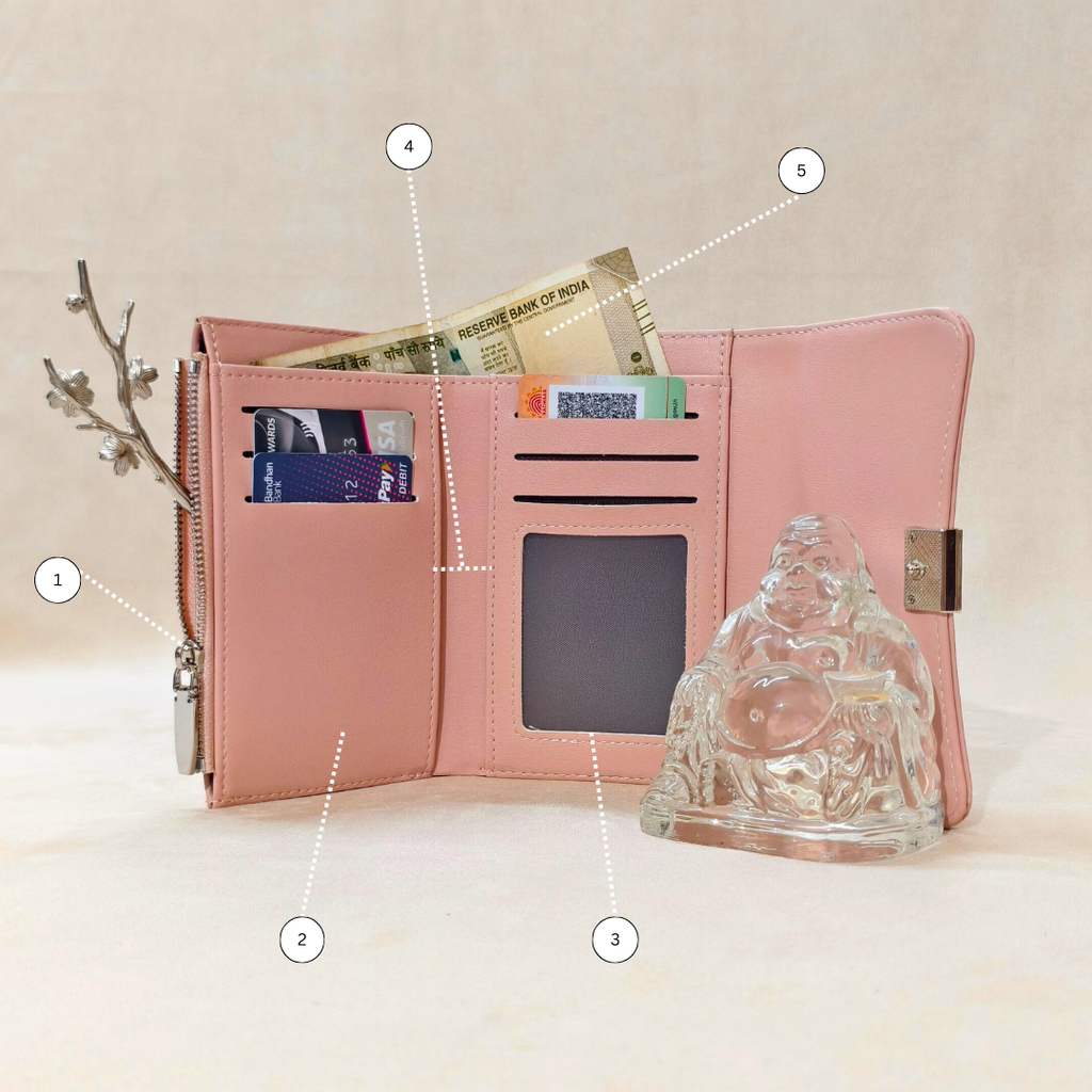Pink wallet with card slots and a glass Buddha statue on a beige background