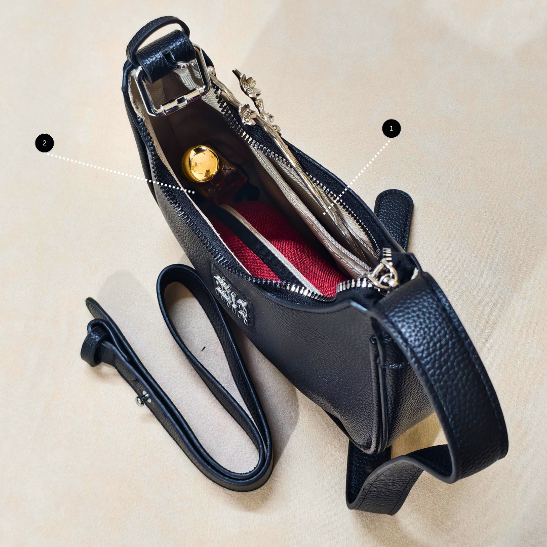 Black leather bag with a strap on a beige background