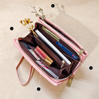 Pink wallet with compartments and items on a beige background