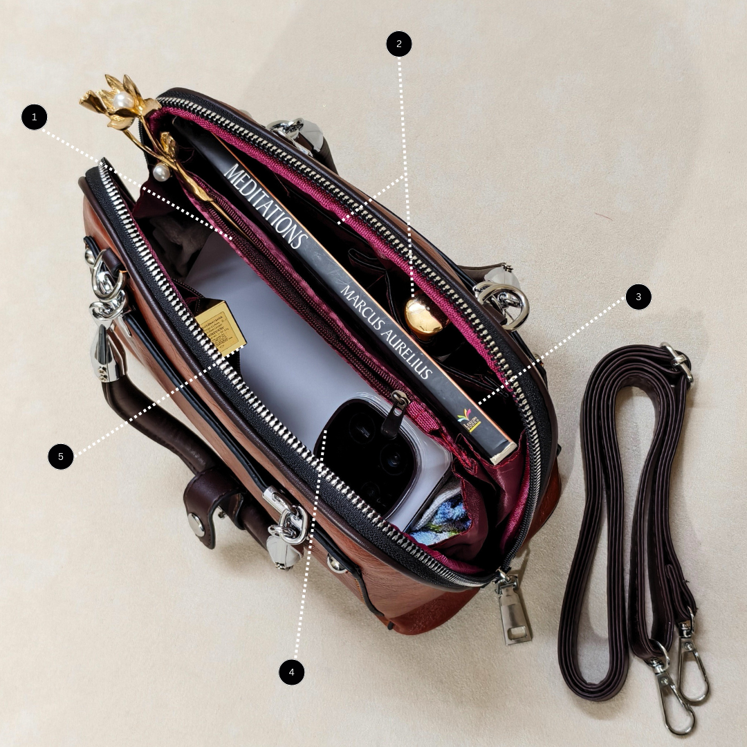 Open handbag with a book titled 'Meditations' by Marcus Aurelius, on a beige background.