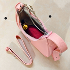 Pink handbag with a strap on a beige background