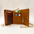 Brown leather wallet with chain strap on a beige background