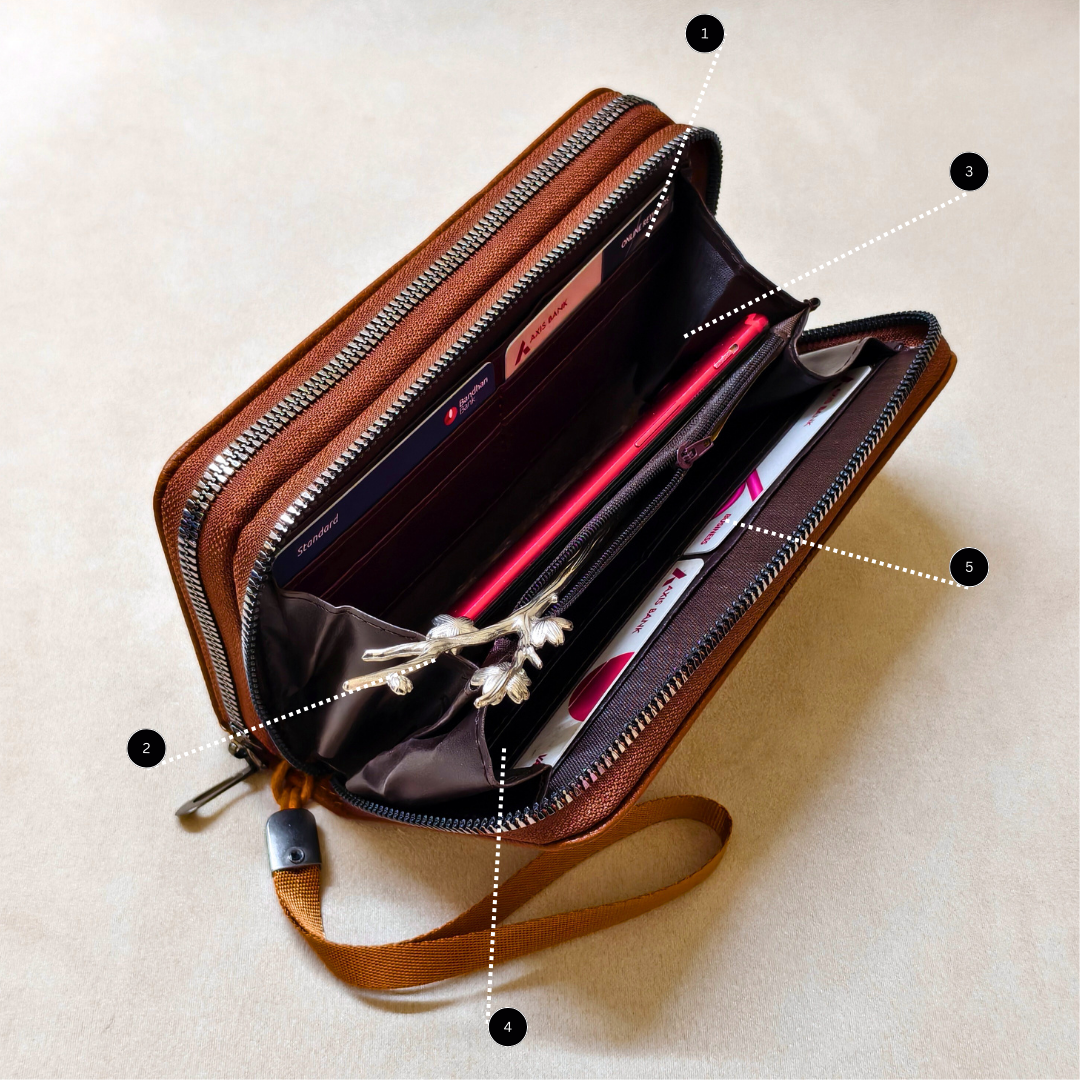 Brown leather crossbody bag with compartments on a beige background