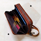 Brown leather crossbody bag with makeup items on a light background
