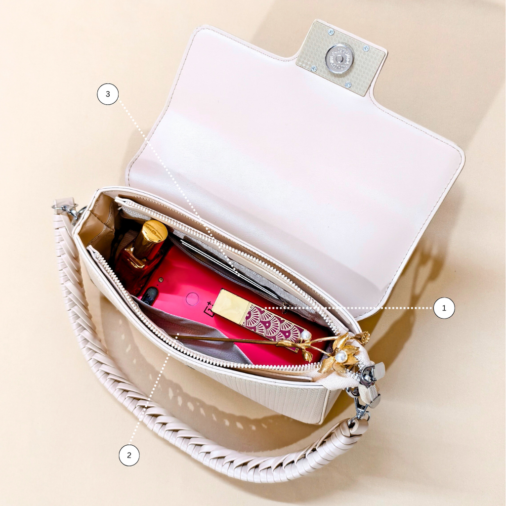 Open white handbag with items inside on a beige background