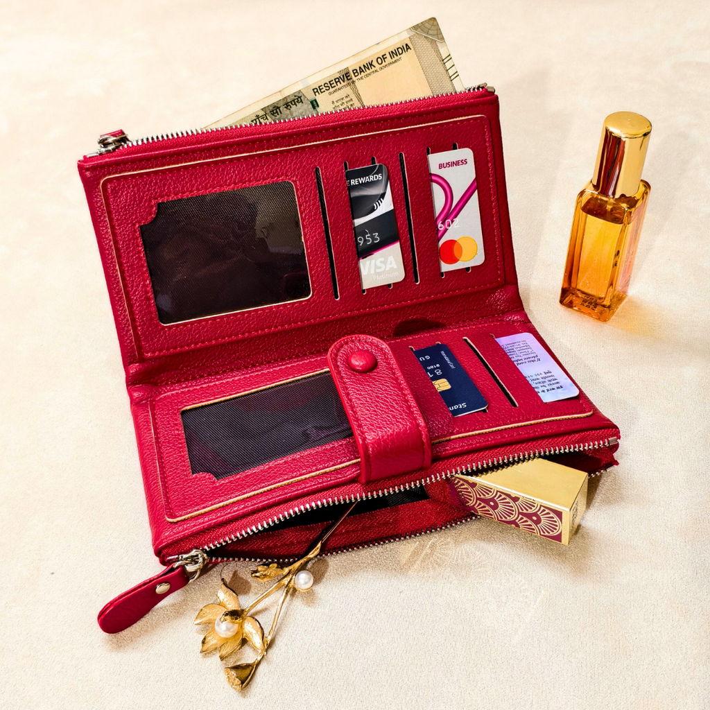 Red wallet with card slots and a small mirror, placed on a textured surface with a perfume bottle and money in the background.
