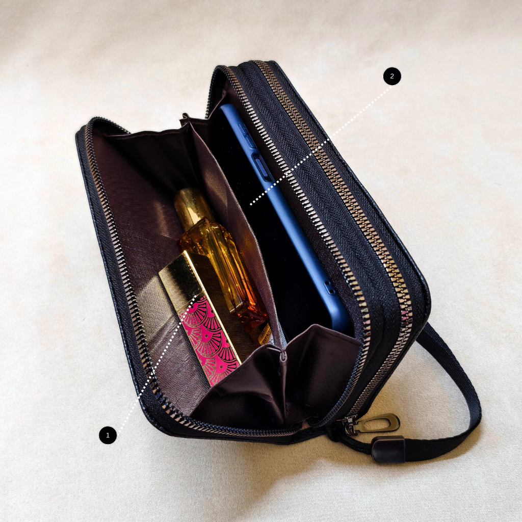 Black travel pouch with compartments containing a bottle and a phone on a beige background