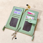 Light green wallet with card slots and a zipper on a beige background